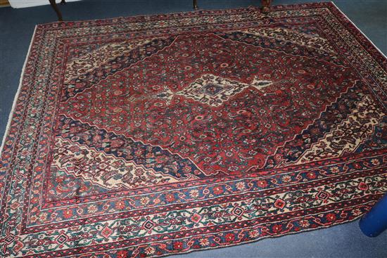 A Hamadan red ground carpet, 10ft 8in by 8ft 3in.